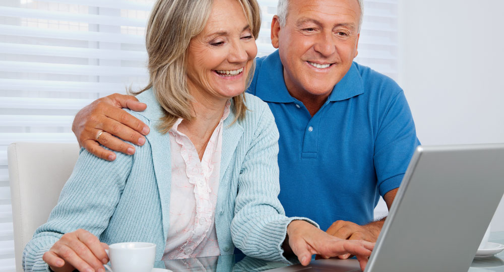 happy older couple looking at a computer